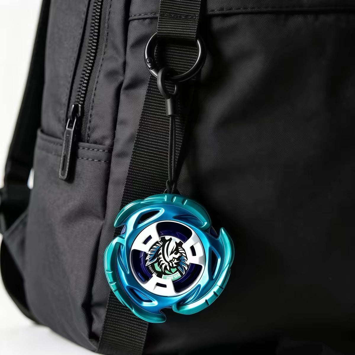 Beyblade keychain clipped to a black backpack strap