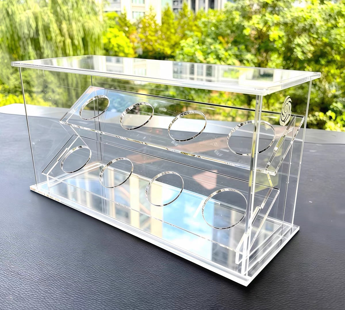 Empty clear acrylic Beyblade display case outdoors showing 8 cutout holders